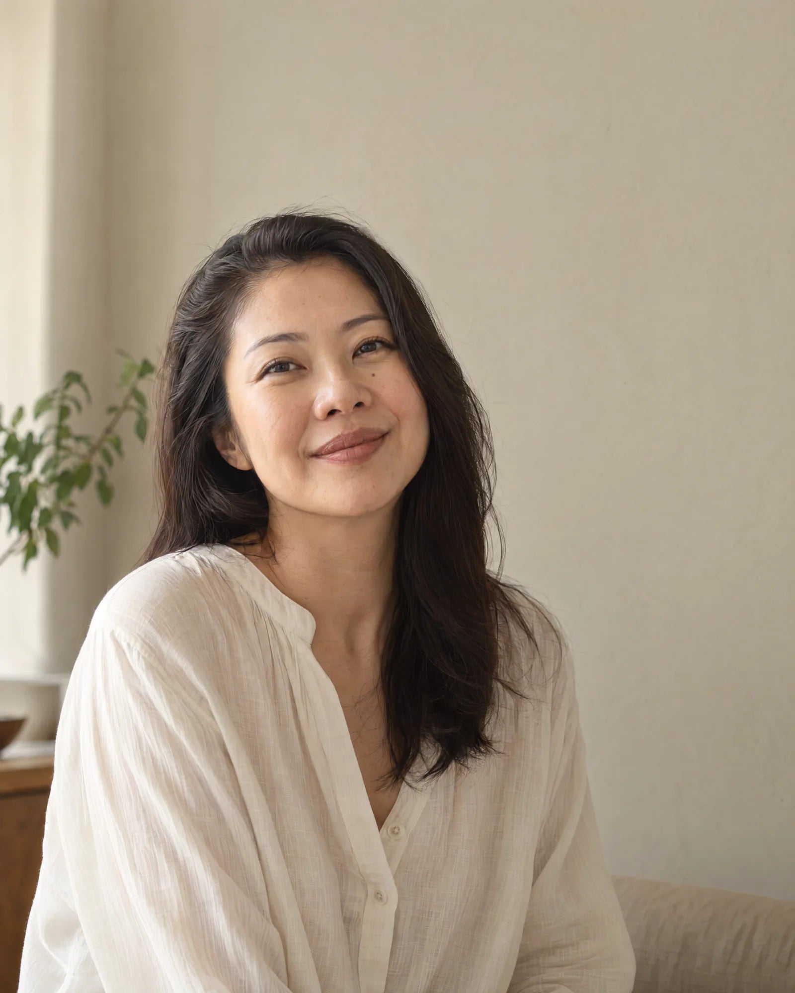 
A woman resting her hand on her shoulder in natural light